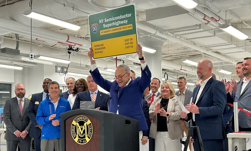 Senator Schumer, in front of other leaders, holds sign that says Route 90, 'ny semiconductor superhighway.'